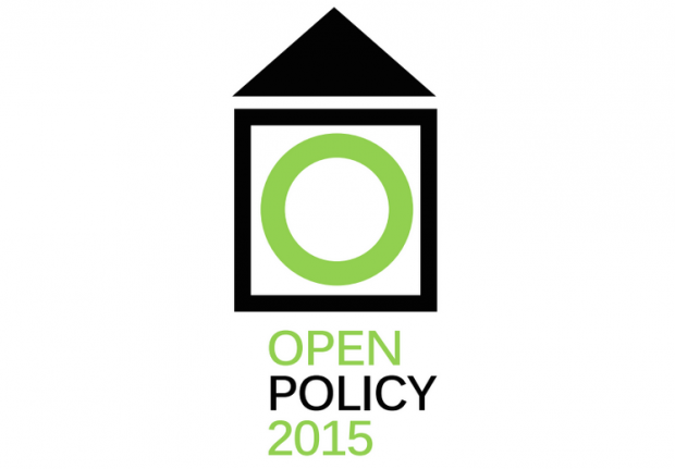 The Open Policy 2015 logo is a black triangle pointing upwards over a black-outlined square with a green circle within. Underneath it says Open Policy 2015 in green and black.