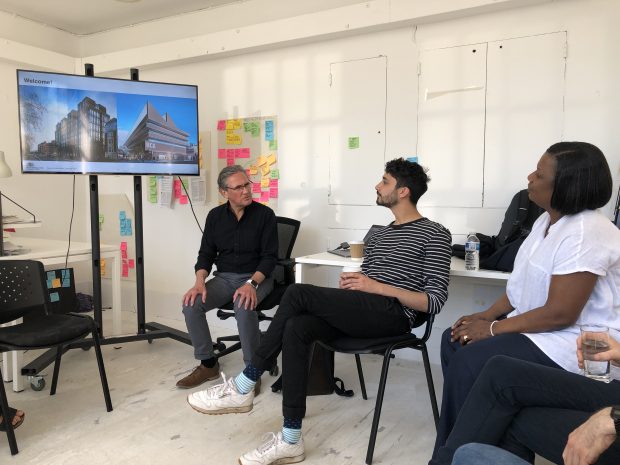 A couple of team members sat in the Royal College of Art during a presentation