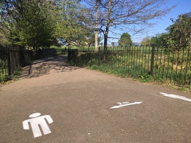 This is a photo of social distancing signs painted onto the ground in Brockwell Park, South London