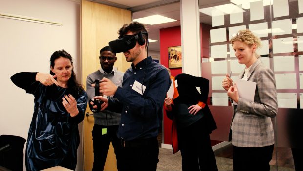 This is an image of people using Virtual Reality headsets to experience townscapes in Los Angeles, Johannesburg and Poundbury without leaving the room.